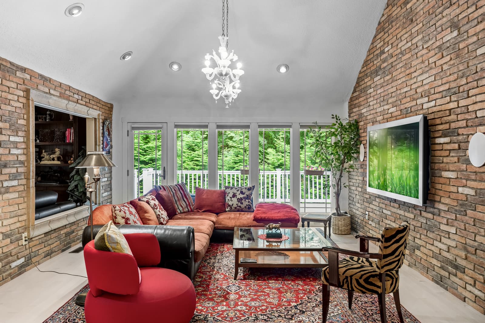 Vaulted living room with a brick accent wall and a wall of windows in Cherry Hill, NJ