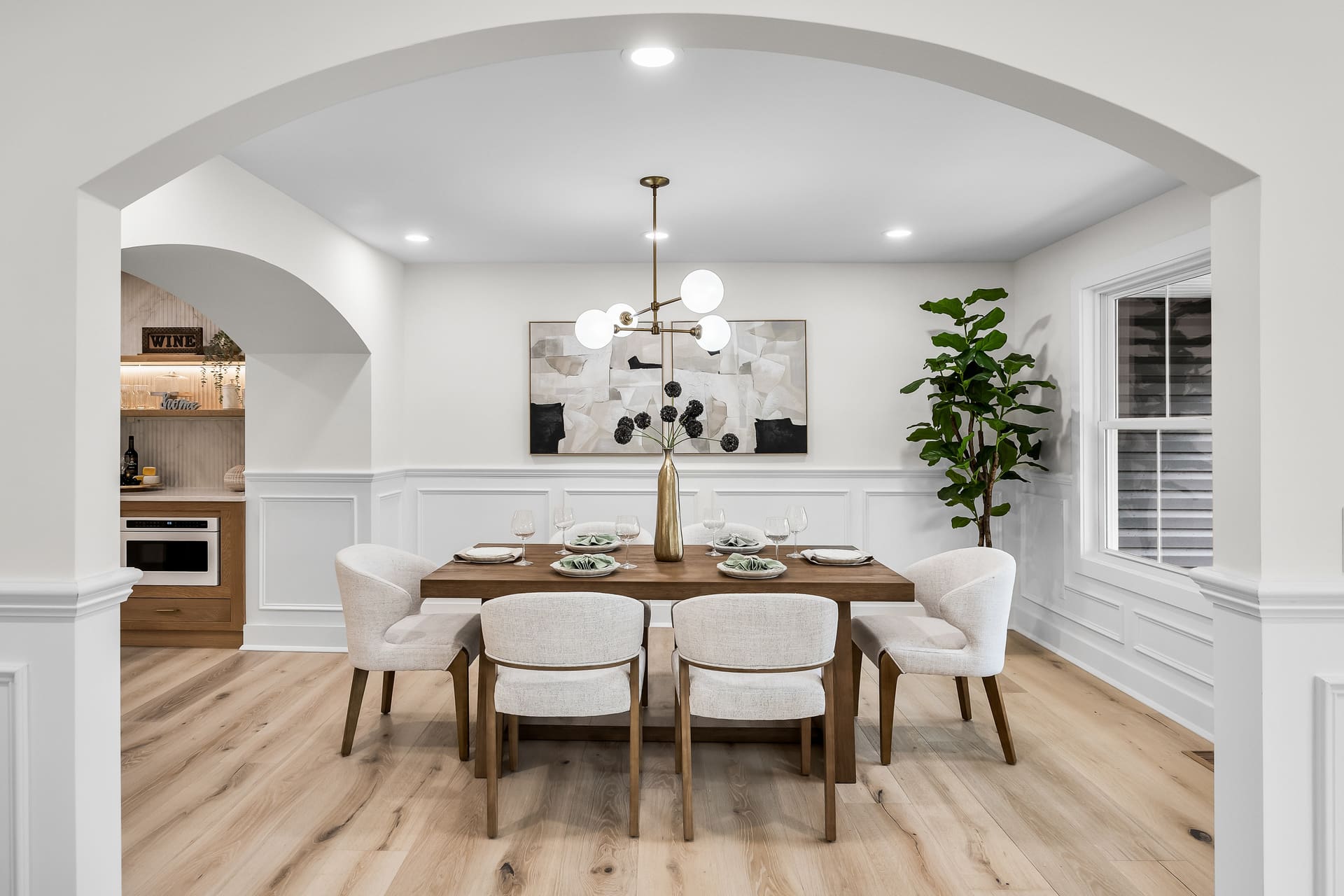Staged dining room seen through an arched entry in a Haddonfield, NJ home