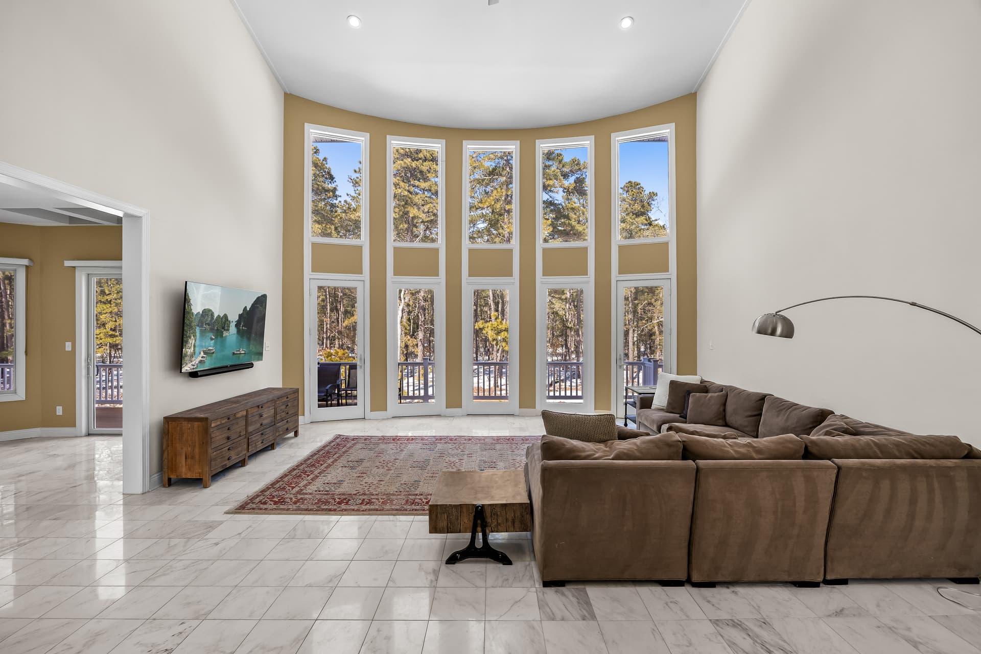Living room framed by a two-story wall of windows in a Marlton, NJ home