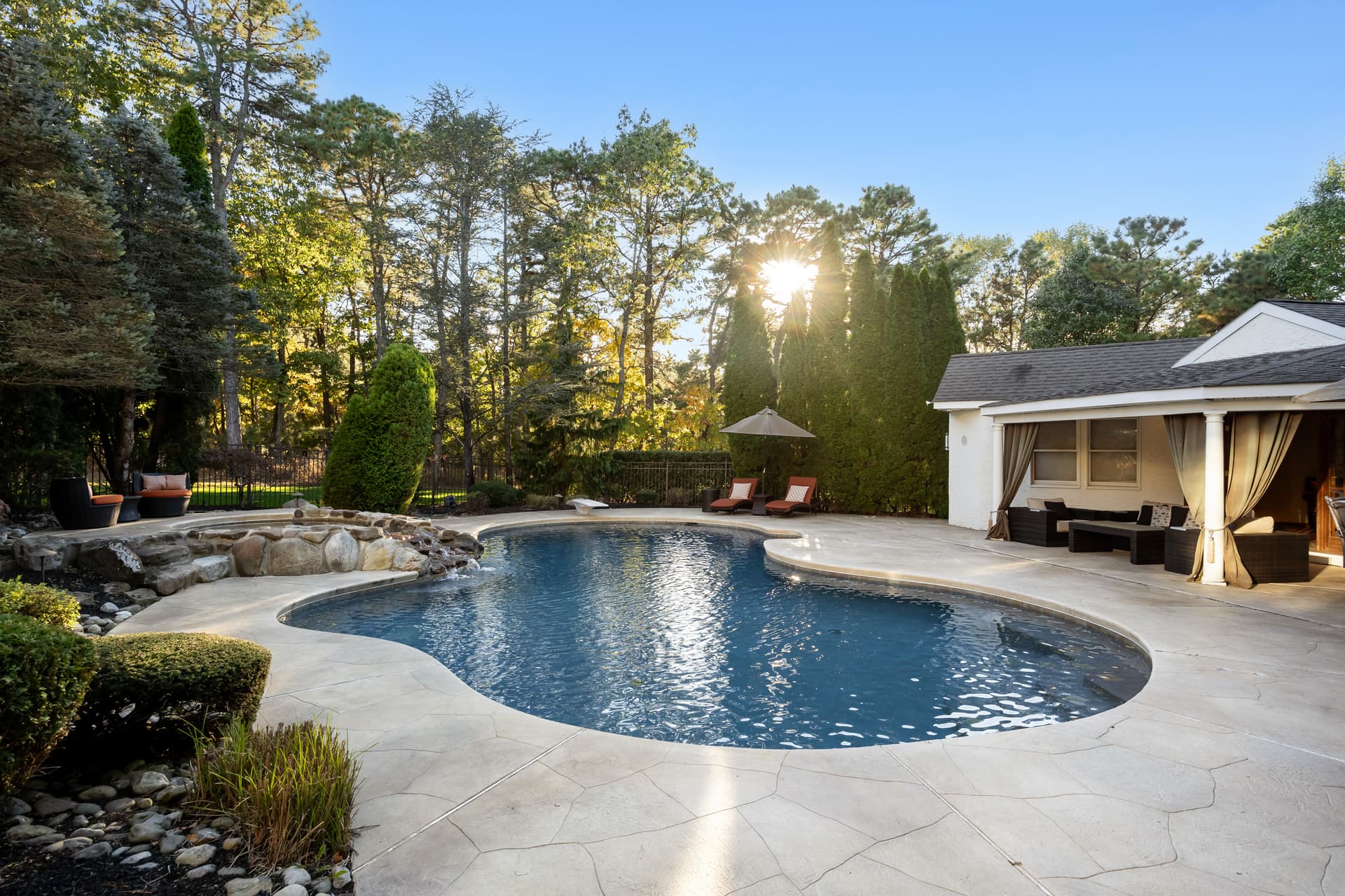 Freeform backyard pool with a cabana and mature landscaping at a Marlton, NJ home
