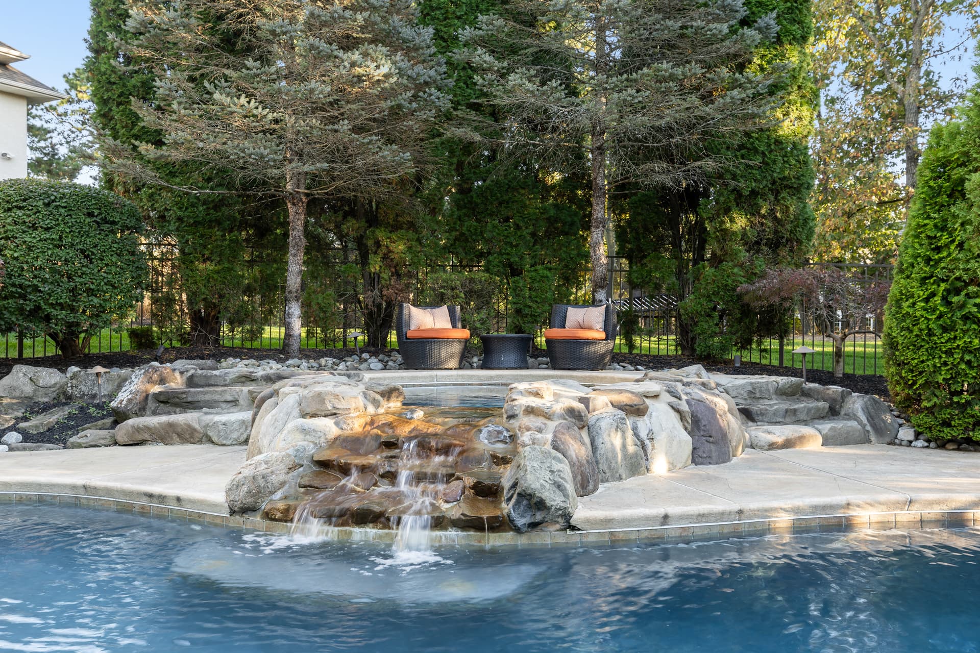 Resort-style pool with a rock waterfall and fire features at a Marlton, NJ home