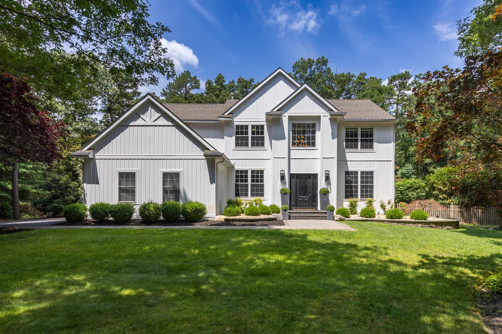 White modern farmhouse exterior with a manicured front lawn in Medford, NJ