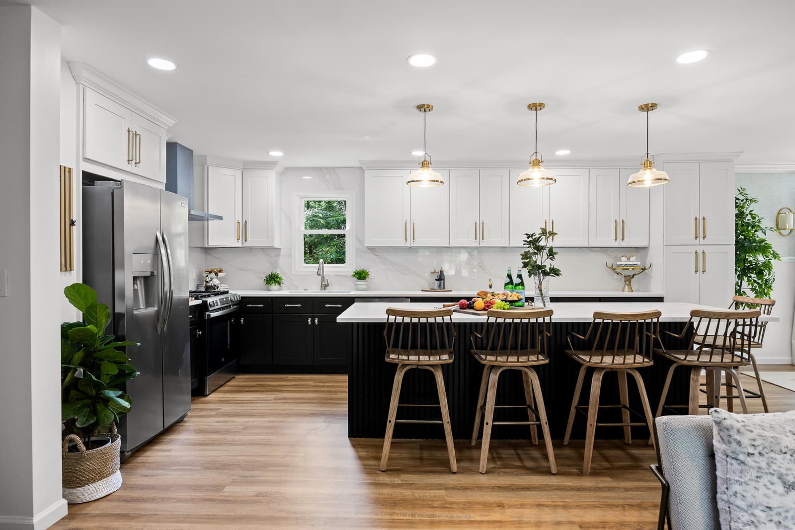 White kitchen with a dark center island, pendant lighting and bar seating in Medford, NJ