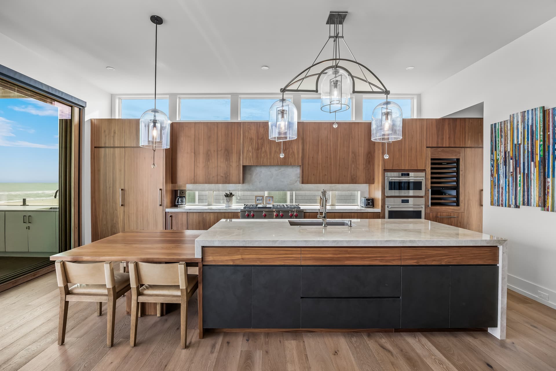 Modern walnut kitchen with a marble waterfall island and ocean view in a South Jersey beachfront estate