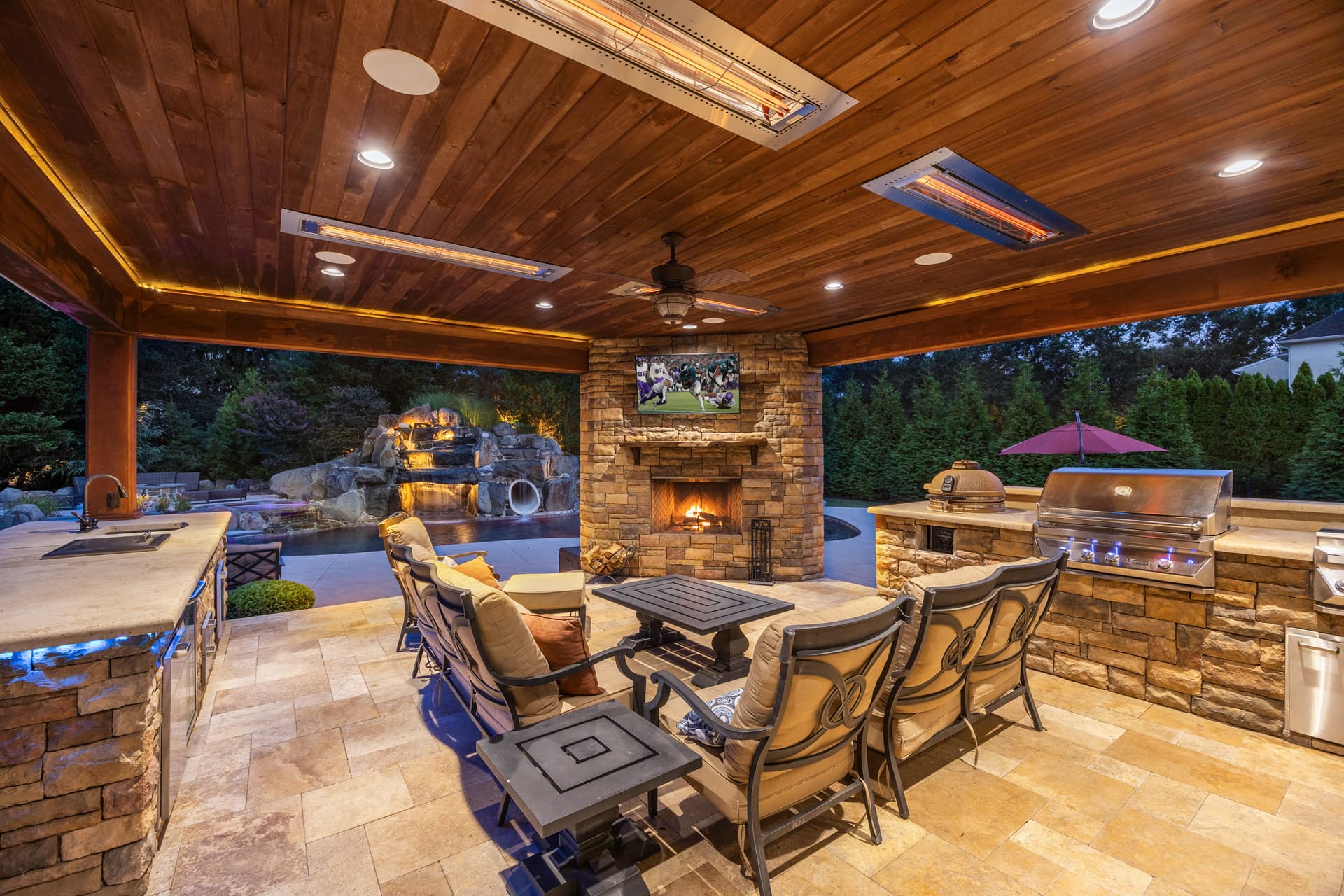 Twilight photography of a covered outdoor living room with fireplace at dusk, South Jersey