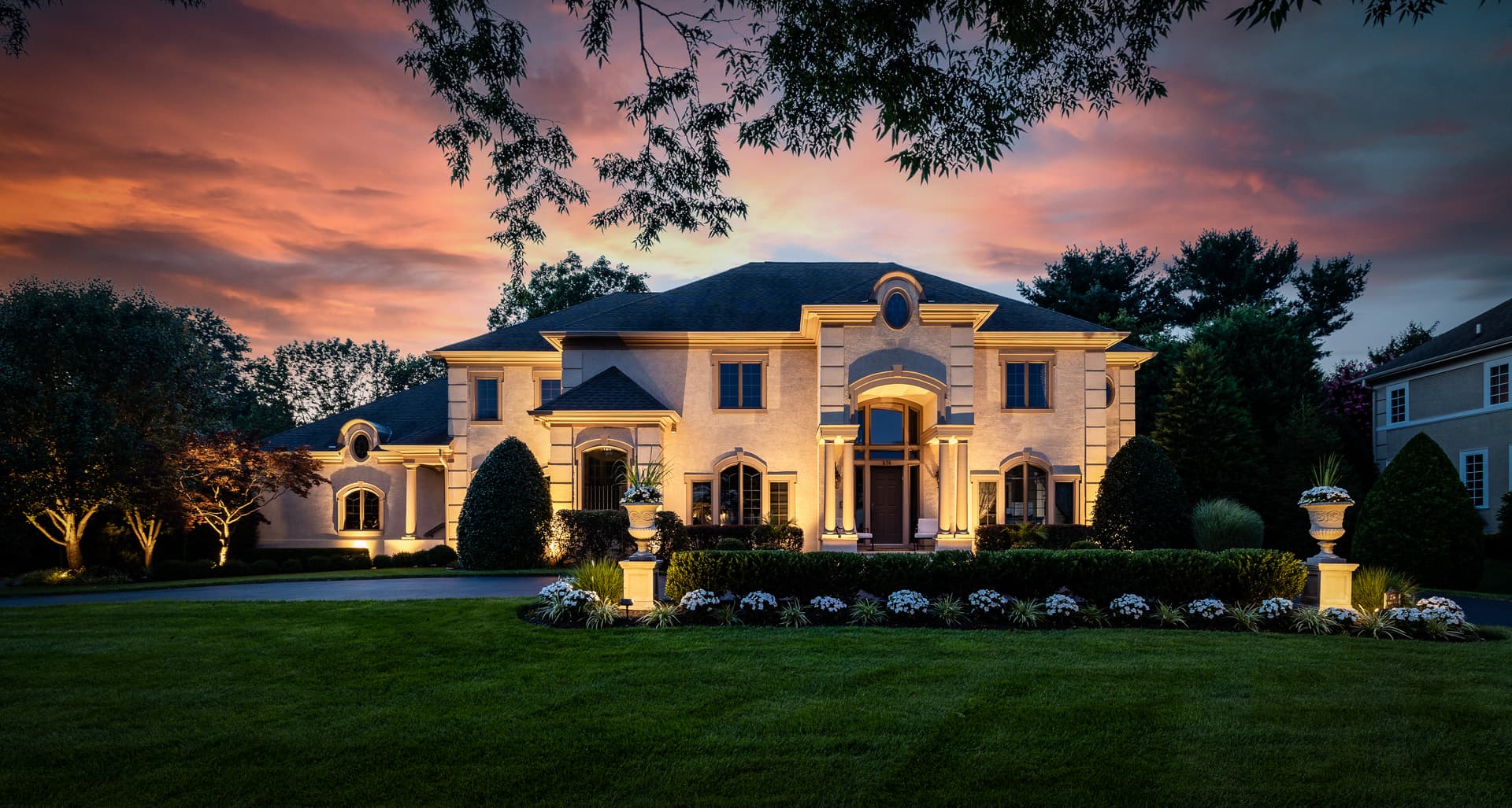 Twilight photography of a grand South Jersey estate glowing at dusk under a dramatic sky